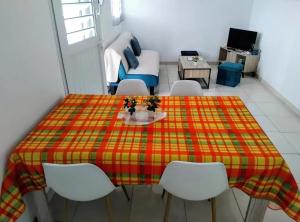 a room with a table and chairs and a couch at Maison charmante à Rivière-Pilote avec vue sur la montagne in Rivière-Pilote