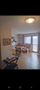 Una sala de estar con una mesa y una gran ventana. en La casa di Grace nella valle incantantata, en Carano