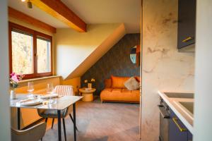 a kitchen and living room with an orange couch at Spalter EINSER - Luxury Apartments & Ferienwohnungen in Spalt