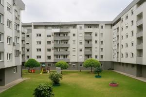 Un edificio de apartamentos con césped delante. en Sajam Nest Apartment, en Novi Sad