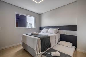 a bedroom with a large bed and a window at Sua estadia completa a poucos minutos do mar em BC – STLs in Balneário Camboriú