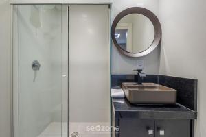 a bathroom with a sink and a shower at Sua estadia completa a poucos minutos do mar em BC – STLs in Balneário Camboriú +17 photos
