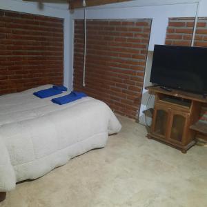 una camera da letto con un letto e una TV a schermo piatto di dpto MDZ a Comodoro Rivadavia