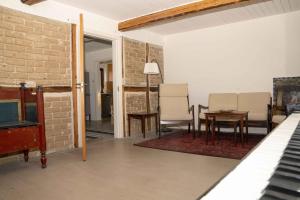 a living room with chairs and a table and a piano at Renovated Country Home 50 M From The Sea in Blans