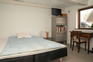 a bedroom with a bed and a desk and a window at Renovated Country Home 50 M From The Sea in Blans