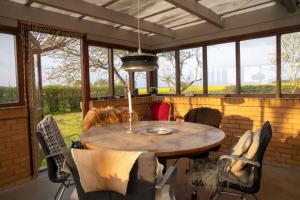 a table and chairs in a room with windows at Renovated Country Home 50 M From The Sea in Blans
