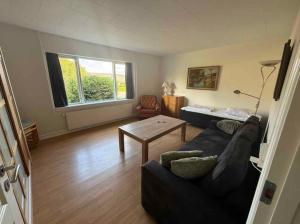a living room with a couch and a table at The Coziest Farm Holiday In The Countryside in Tommerup