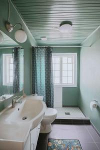 a bathroom with a white sink and a toilet at Stay In Hindemaes Historic Managers House in Ullerslev