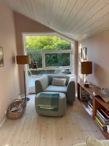 a living room with a couch and a large window at Holiday Oasis With Terrace And Sloping Garden in Tikøb