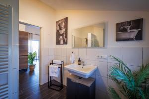 un bagno con lavandino e specchio di Modernes City Apartment in Lübbecke mit Terrasse a Lübbecke Altre 15 foto