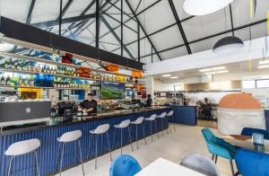 a restaurant with blue chairs and a bar with a chef at Beachfront Getaway in Gqeberha