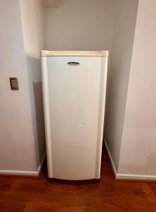 a white refrigerator in a corner of a room at Moderno Apartamento a pasos del Metro y Museo Bellas Artes, Cerro Santa Lucia, Barrio Lastarria in Santiago +5 photos