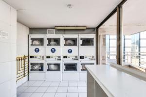 a laundry room with washers and dryers at Moderno Apartamento a pasos del Metro y Museo Bellas Artes, Cerro Santa Lucia, Barrio Lastarria in Santiago