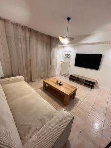 ein Wohnzimmer mit Couch und Flachbildfernseher in der Unterkunft Logement autonome 2 a 4 personnes in Poitiers