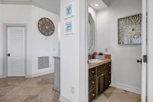 een badkamer met een wastafel en een klok aan de muur bij Sea Haven - Oceanfront home w pvt beach & deck in Ponte Vedra Beach +40 foto's