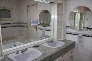 ein Badezimmer mit zwei Waschbecken und einem großen Spiegel in der Unterkunft Aparthotel Maison Suisse in Asunción + 24 Fotos