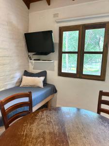 a room with a table and a flat screen tv at La Ribera Aparts in Santa Rosa de Calamuchita