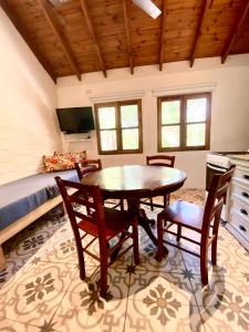 a dining room with a table and chairs and a bed at La Ribera Aparts in Santa Rosa de Calamuchita