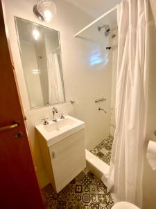 a white bathroom with a sink and a shower at La Ribera Aparts in Santa Rosa de Calamuchita +17 photos