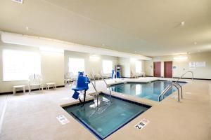 a large pool in a hospital room with chairs and tables at Cobblestone Hotel & Suites - Devils Lake in Devils Lake