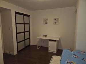 Spacious basement with private bathroom , sitting room and TV في ماركهام: غرفة مع طاولة وسرير ومكتب