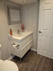 Spacious basement with private bathroom , sitting room and TV في ماركهام: حمام مع حوض ومرحاض