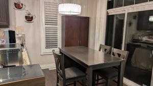 Spacious basement with private bathroom , sitting room and TV في ماركهام: مطبخ مع طاولة وكراسي في مطبخ +صورة واحدة