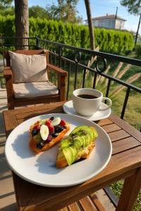 Ein Teller mit Essen und eine Tasse Kaffee auf einem Tisch. in der Unterkunft Kumkat Hotel in Milas