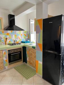 a kitchen with a black refrigerator in a colorful kitchen at Rosa dei venti 3 in Santa Maria