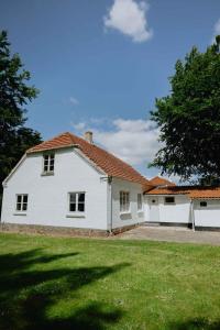 a white house with a large grass yard at Bright Modern Holiday Home Near Hindemae in Ullerslev
