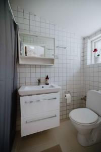 a white bathroom with a toilet and a sink at Bright Modern Holiday Home Near Hindemae in Ullerslev