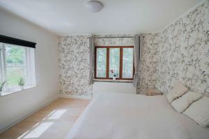 a bedroom with a white bed and a window at Bright Modern Holiday Home Near Hindemae in Ullerslev