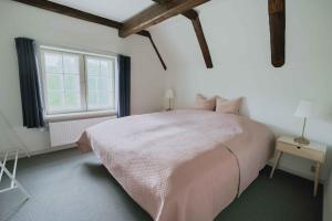a bedroom with a large bed and a window at Hindemae Estate For Holidays And Events in Ullerslev +19 photos