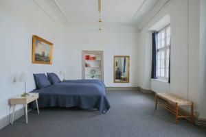 a bedroom with a blue bed and a table at Hindemae Estate For Holidays And Events in Ullerslev