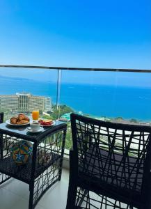 a table with a plate of food on a balcony at Sky residences - Plage de Pattaya Pratamnak Moderne in Pattaya South