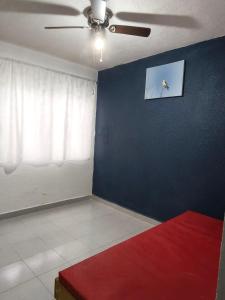 ein Wohnzimmer mit einem Deckenventilator und einem roten Sofa in der Unterkunft Residencial 2 ríos in Dos Ríos