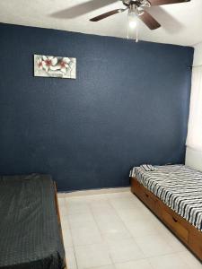 Un dormitorio con una pared azul y una cama. en Residencial 2 ríos, en Dos Ríos 15 fotos más