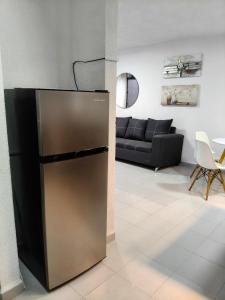 einen Kühlschrank im Wohnzimmer mit Sofa in der Unterkunft Residencial 2 ríos in Dos Ríos + 15 Fotos