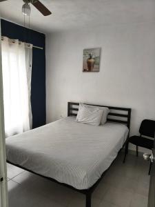 Bett in einem Schlafzimmer mit Deckenventilator in der Unterkunft Residencial 2 ríos in Dos Ríos