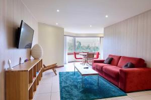 パラマリボにあるTorarica Resortの赤いソファとテーブルのあるリビングルーム