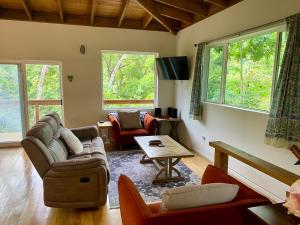 a living room with a couch and a table at Tropical Jungle House in Coxen Hole