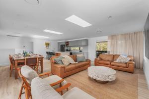 a living room with two couches and a table at Luna Beach House, Vincentia in Vincentia