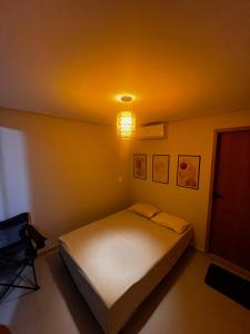 a bedroom with a bed and a light on the ceiling at Enseada Beach in São Sebastião