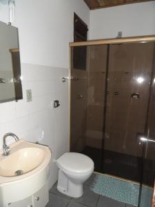 a bathroom with a shower and a toilet and a sink at Hotel Serra De Penedo in Penedo