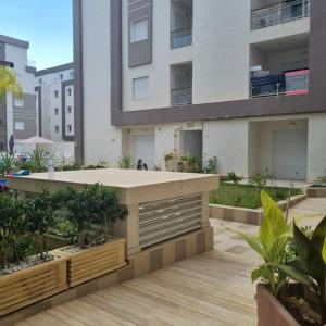 an apartment building with a patio with trees and plants at Appartement Neuf au Bord de la Mer - Hammamet Sud Zone Touristique in Hammamet +9 photos