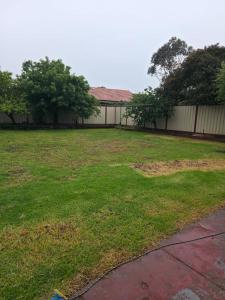 a yard with a fence and a large grass field at 4 Westcott Parade Rockbank in Rockbank