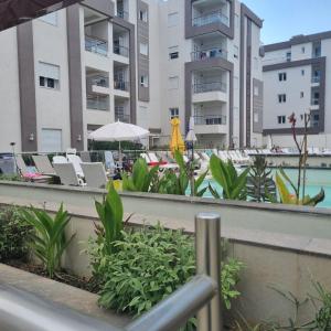 a resort with a pool and chairs and buildings at Appartement Neuf au Bord de la Mer - Hammamet Sud Zone Touristique in Hammamet