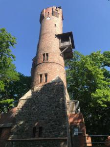 ein hoher Backsteinturm auf einem Gebäude in der Unterkunft Altstadt Quartier in Bad Freienwalde