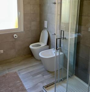a bathroom with a toilet and a glass shower at La vista Azzurra in Bordighera