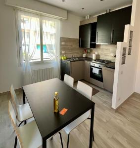 a kitchen with a black table and chairs in a room at La vista Azzurra in Bordighera +8 photos